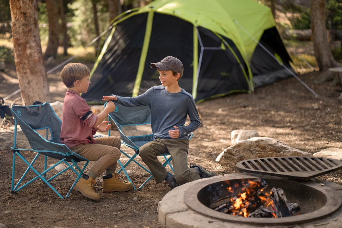 Campers seated beside a Coleman Carlsbad tent