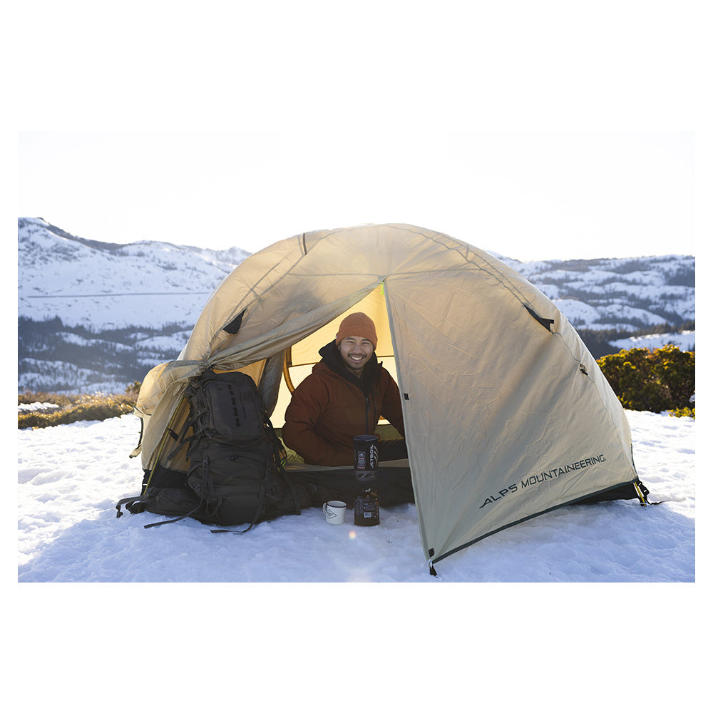 ALPS Taurus Outfitter tent pitched at a snowy campsite with the vestibule open