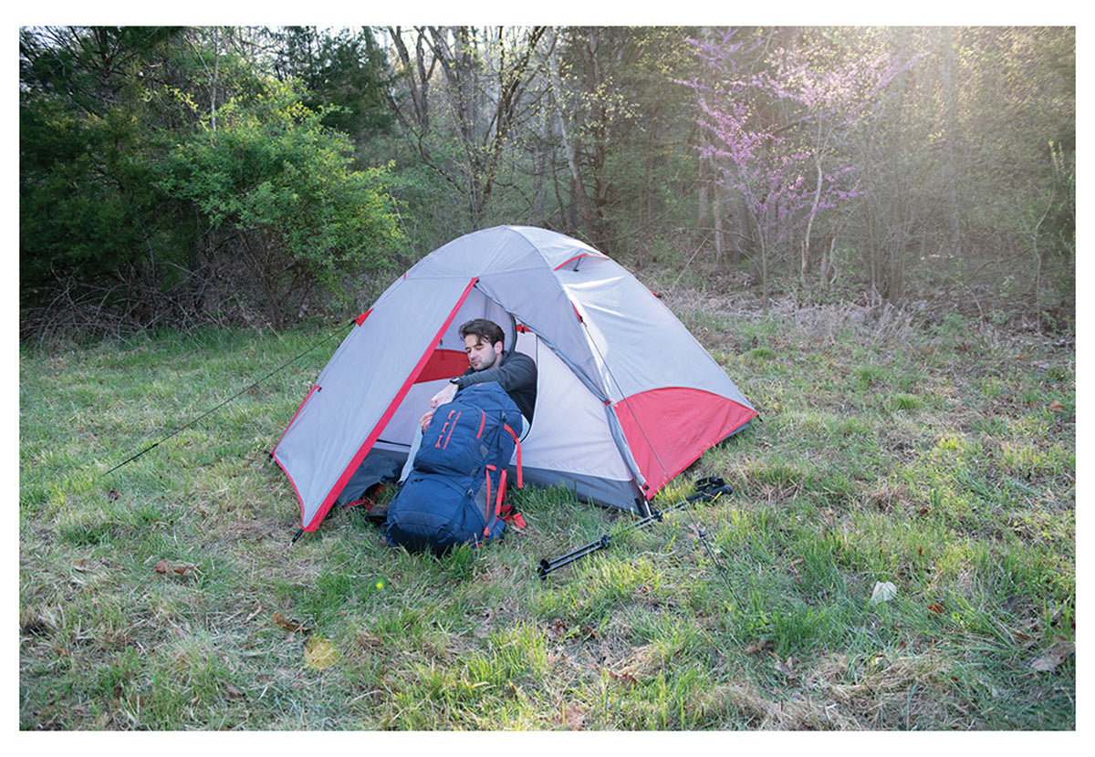 Camper sitting at the open entrance of an ALPS Taurus tent