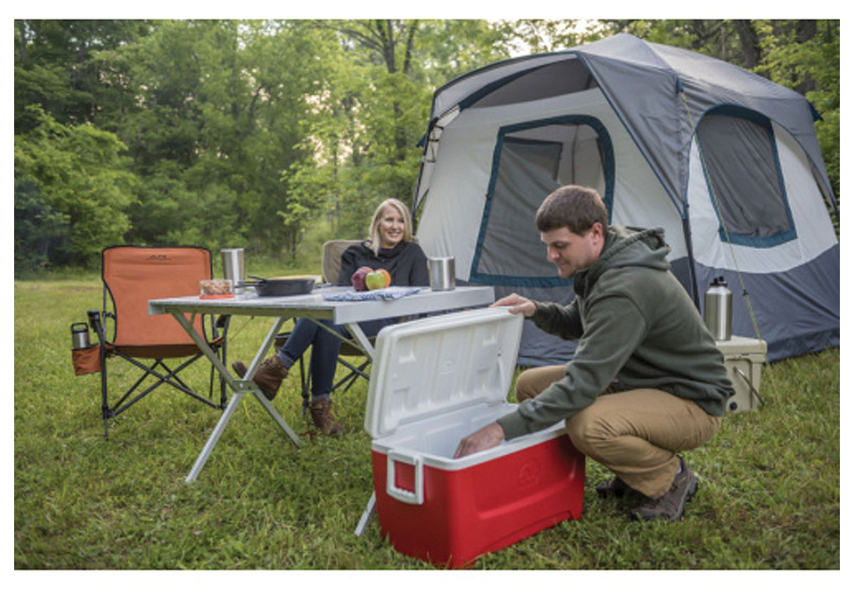 Campsite with folding chairs, aluminum table, tent and open cooler