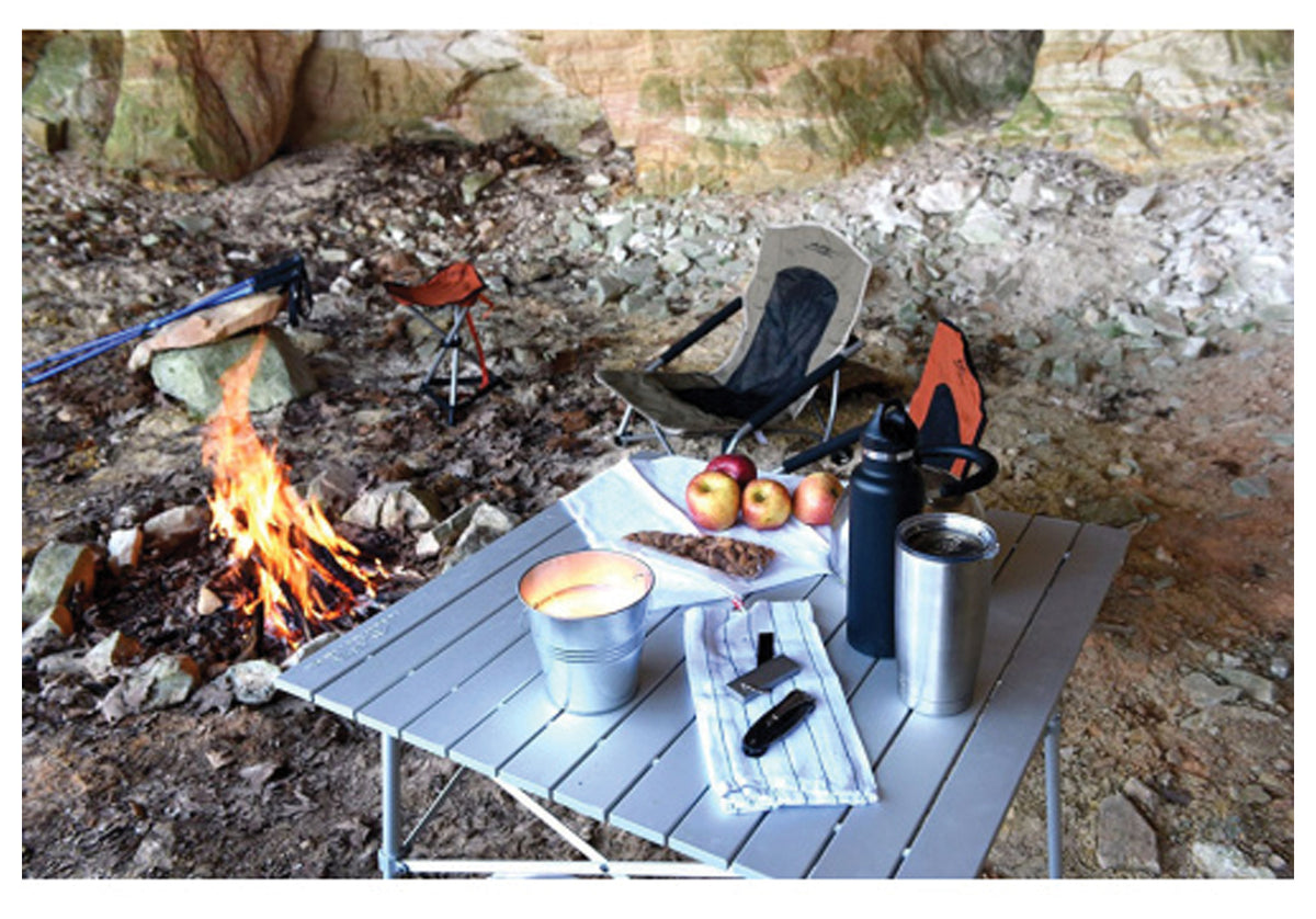 Silver ALPS Camp Table holding cookware and food beside a campfire