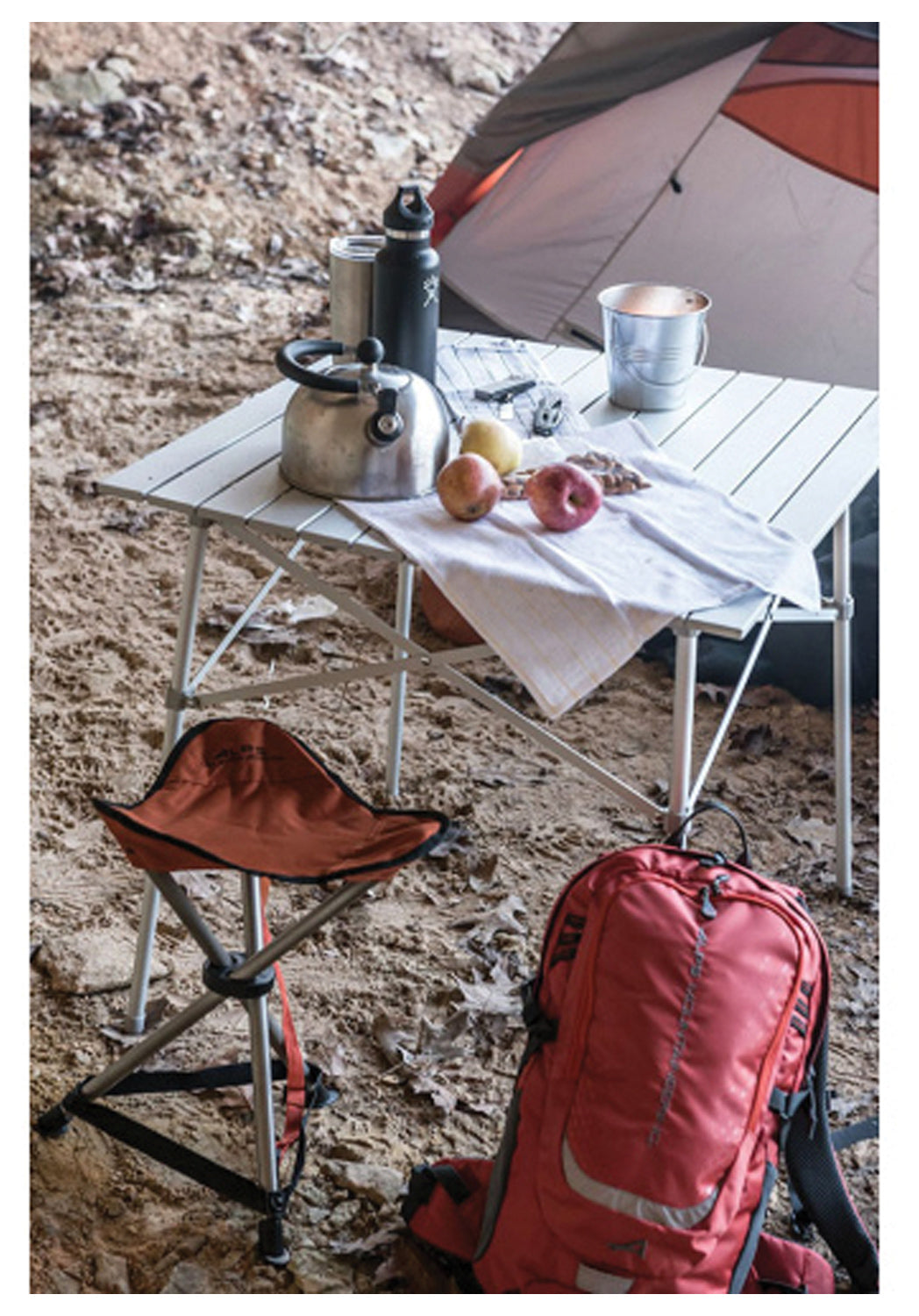 ALPS Camp Table with dishes and a kettle beside a tent, stool and backpack