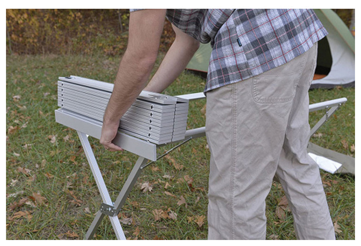 Camper folding the slatted top of an ALPS aluminum dining table