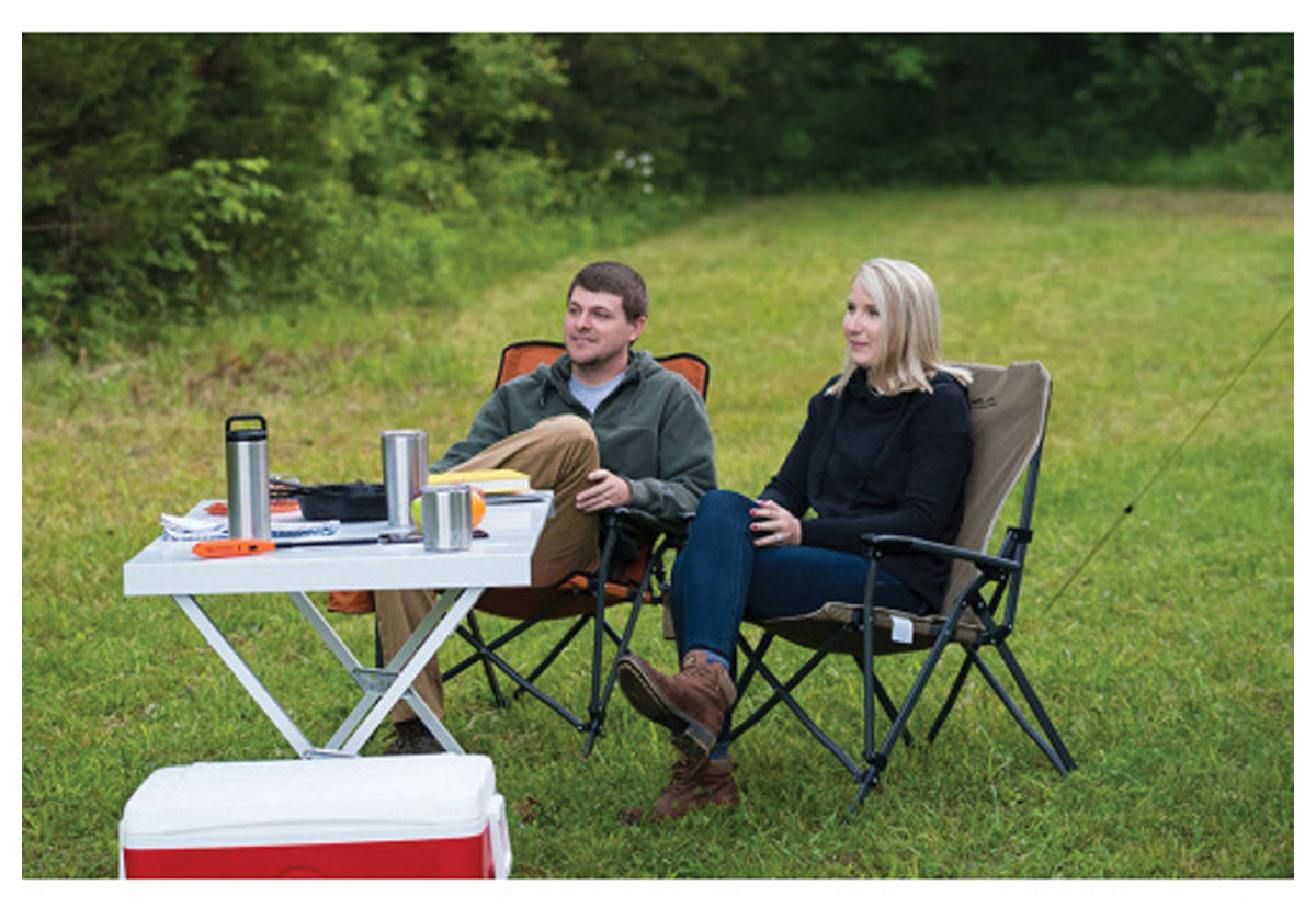 Campers seated beside an ALPS aluminum dining table with drinks outdoors