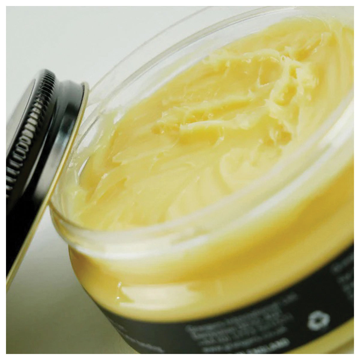 Open jar showing the soft yellow Grangers Waterproofing Wax