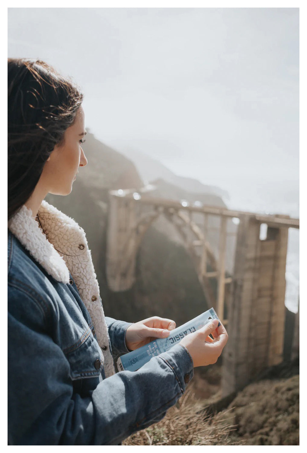 Person holding a Classic Beef Stick from The New Primal on an outdoor deck