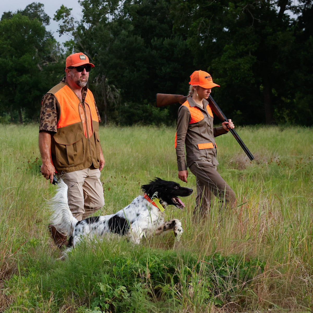 Handlers and dogs wearing Hoss collars in a field