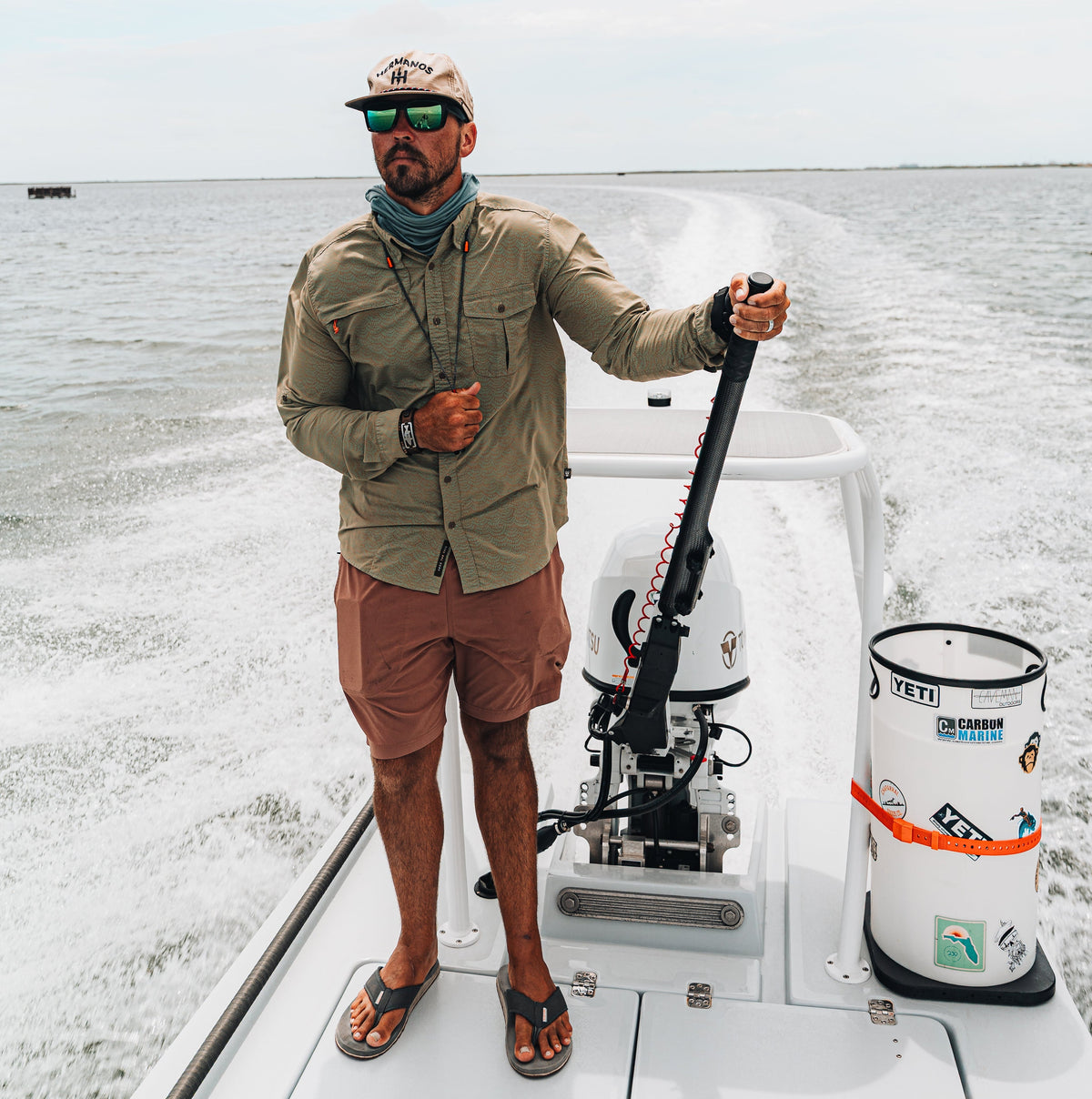 Angler beside a boat bucket and Hoss strap setup