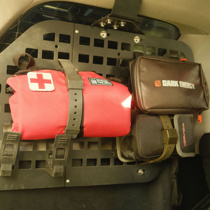 Hoss straps holding first-aid and utility pouches on a wall panel