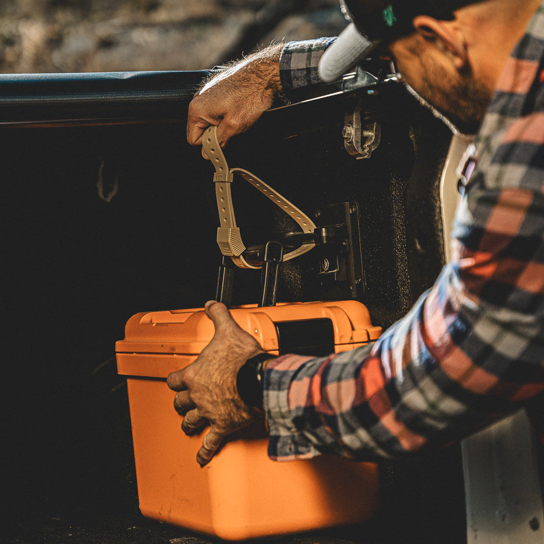 Person securing an orange bucket with a Hoss strap