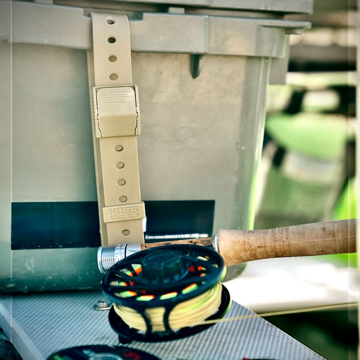 Hoss gear strap securing a fishing rod beside a cooler