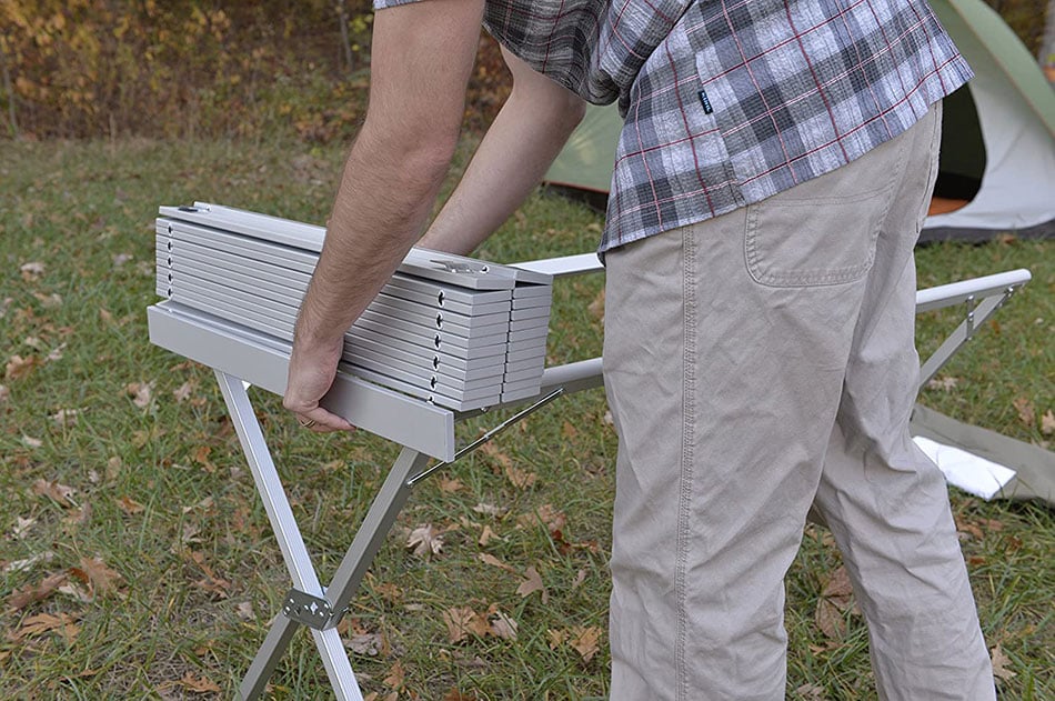 Camper rolling the slatted top across an ALPS aluminum dining table frame