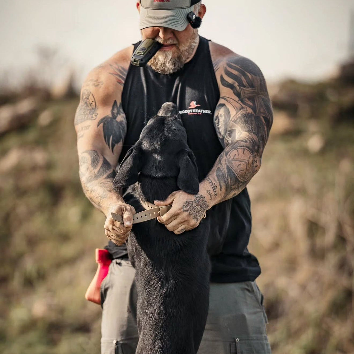 Handler holding a Hoss collar beside a dog