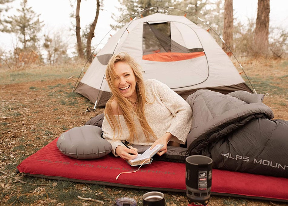 Camper resting on a red ALPS Apex pad on a cot