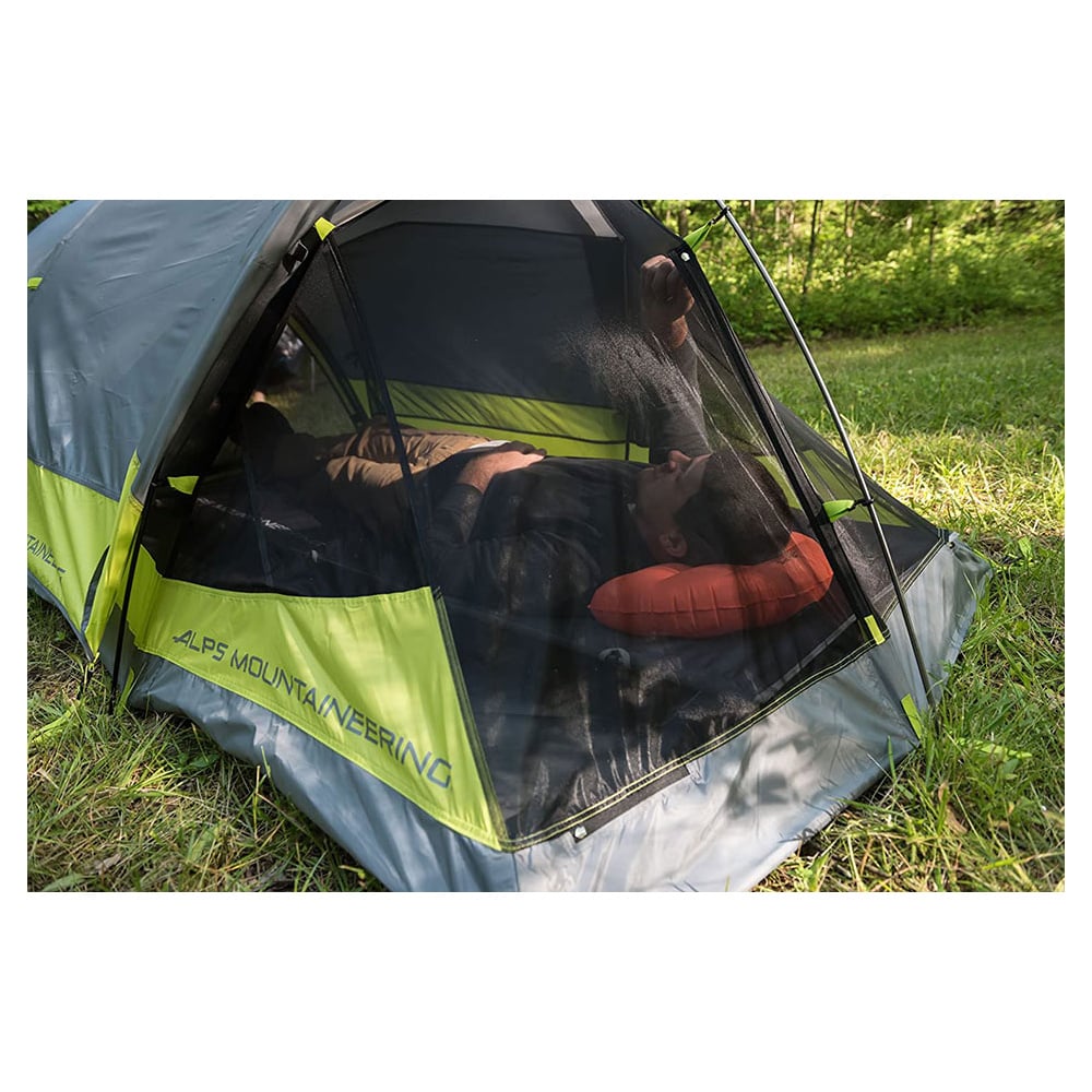 Camper resting on an orange ALPS Versa pillow inside a tent