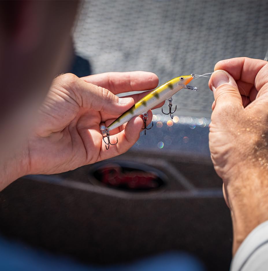 Hands tying fishing line to a Rapala Original Floating lure