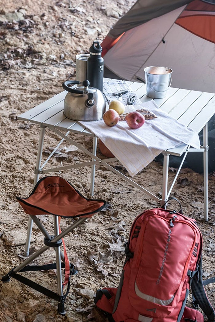 ALPS Camp Table set with food and a kettle beside a tent and backpack