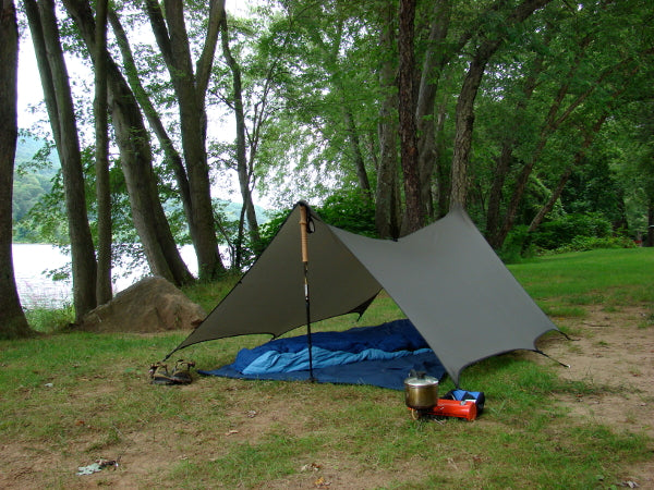 Equinox Myotis sculpted tarp pitched at a campsite; support poles and other camp gear shown are not included