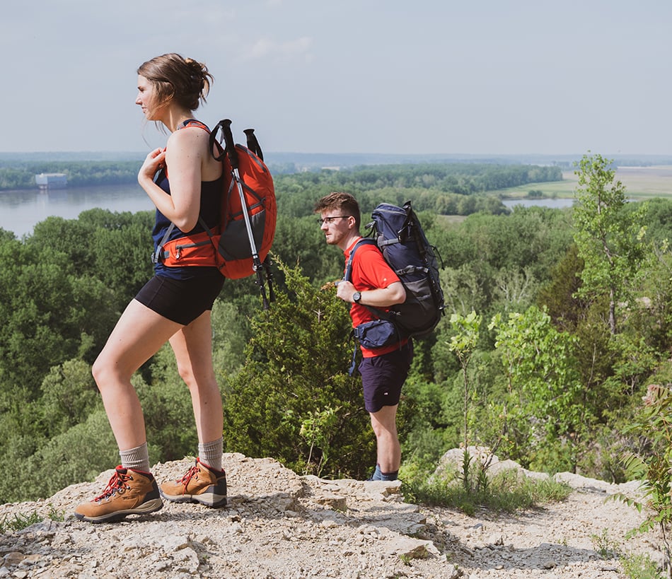 Two hikers carrying backpacks on a wooded trail