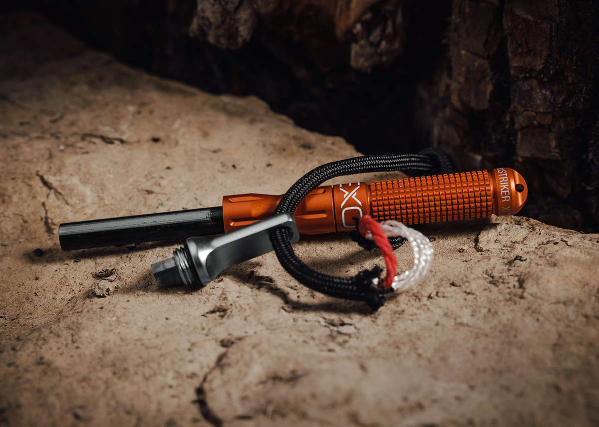 Orange Exotac nanoSTRIKER XL opened on a campsite surface