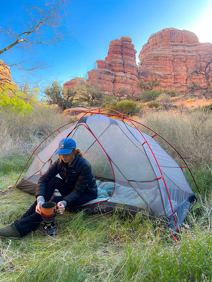 Camper sitting in an ALPS Helix mesh tent near red rock formations