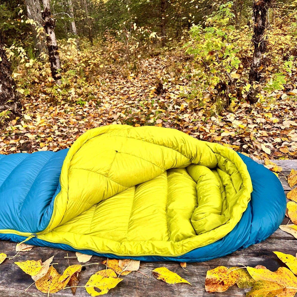 Peregrine Anatum sleeping bag opened on a picnic table to show the yellow lining