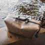 Flat Dark Earth Magpul DAKA Takeout Large bag resting on a rock beside water