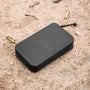 Black Magpul DAKA Utility Organizer, Standard, resting on sandy ground