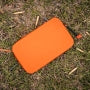 Orange Magpul DAKA Utility Organizer, Standard, resting on the ground