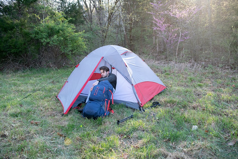 Camper seated at the open entrance of an ALPS Taurus tent