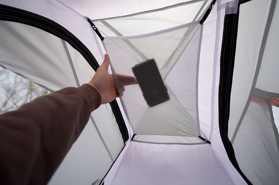 Phone being placed in an ALPS Taurus interior mesh storage pocket